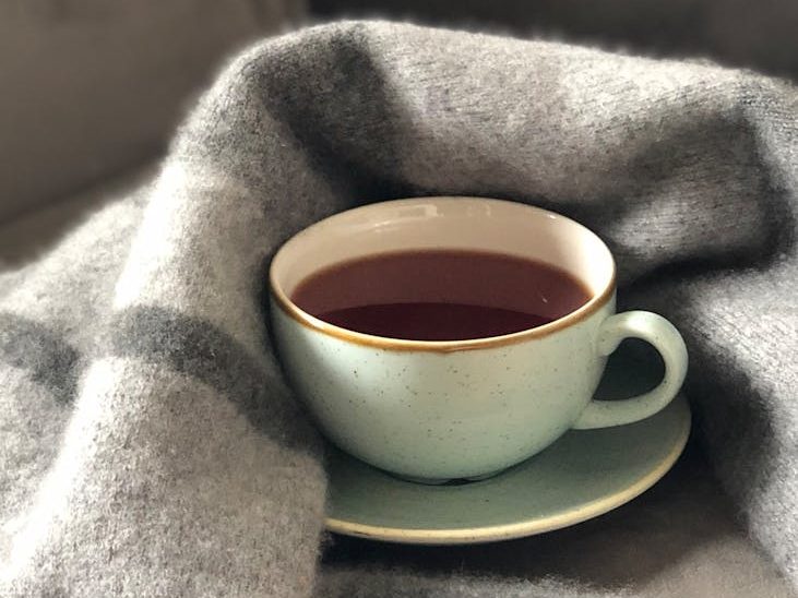 Cup of tea in sunlight with blanket