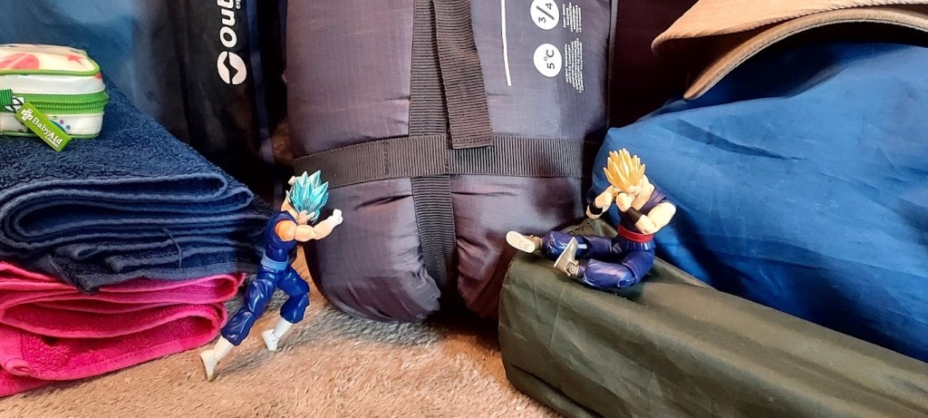 Action figures pushing against the weight of different packing and camping items