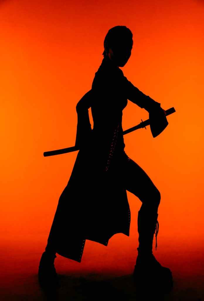 silhouette of woman in attack stance with ninja style sword