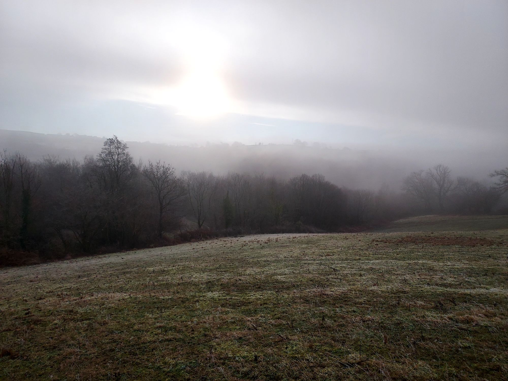 Low winter sun over misty hilltops