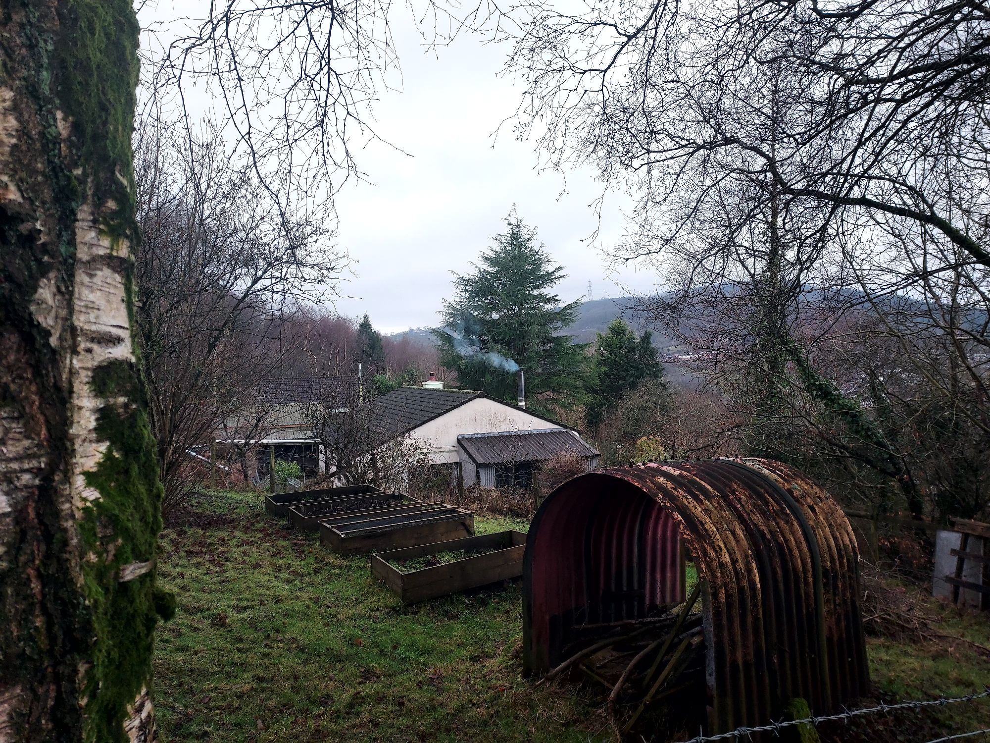 Farm land and buildings with smoke curling from chimney
