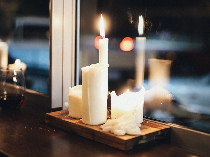 Candles on a windowsill with dark snowy night outside