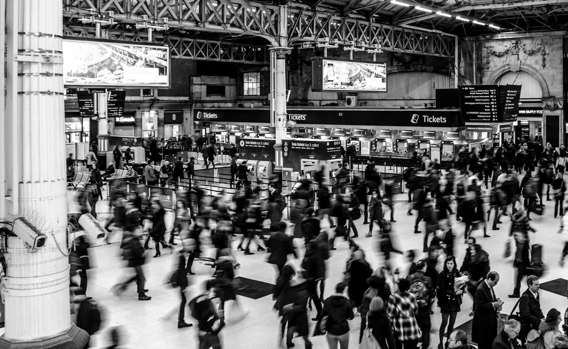 Busy train station with fast moving blurry masses of people