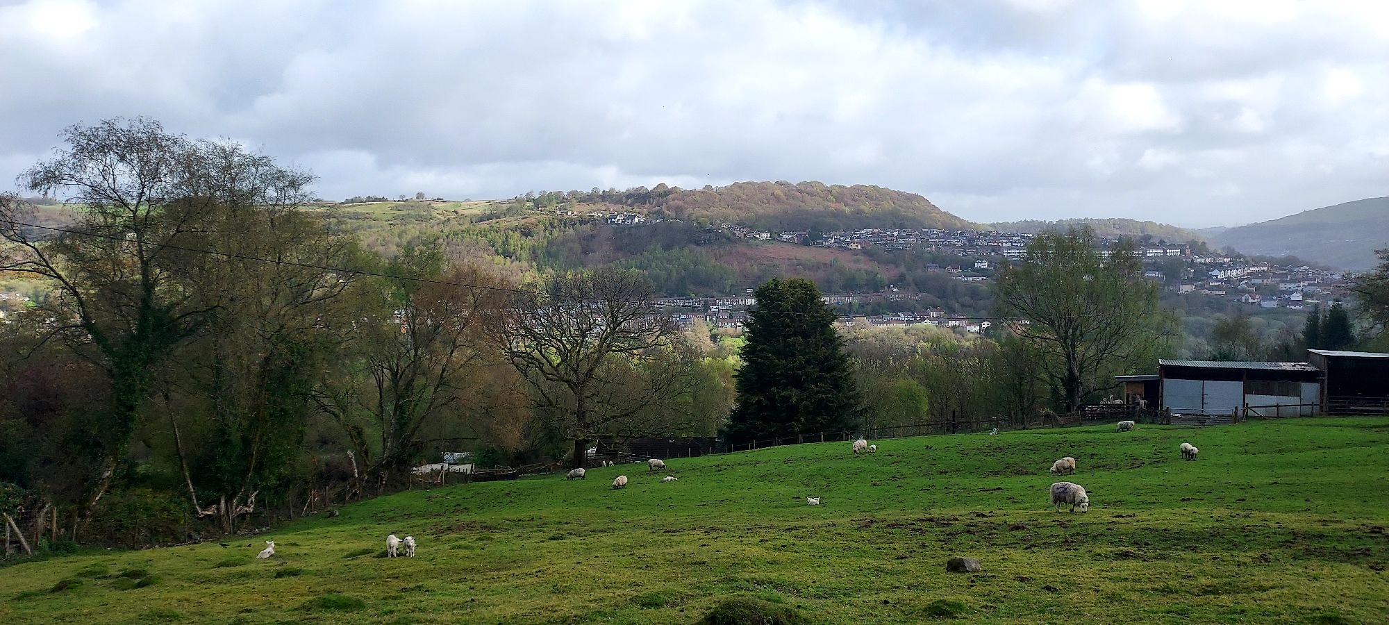 View over farmland with light and shade on hills beyond